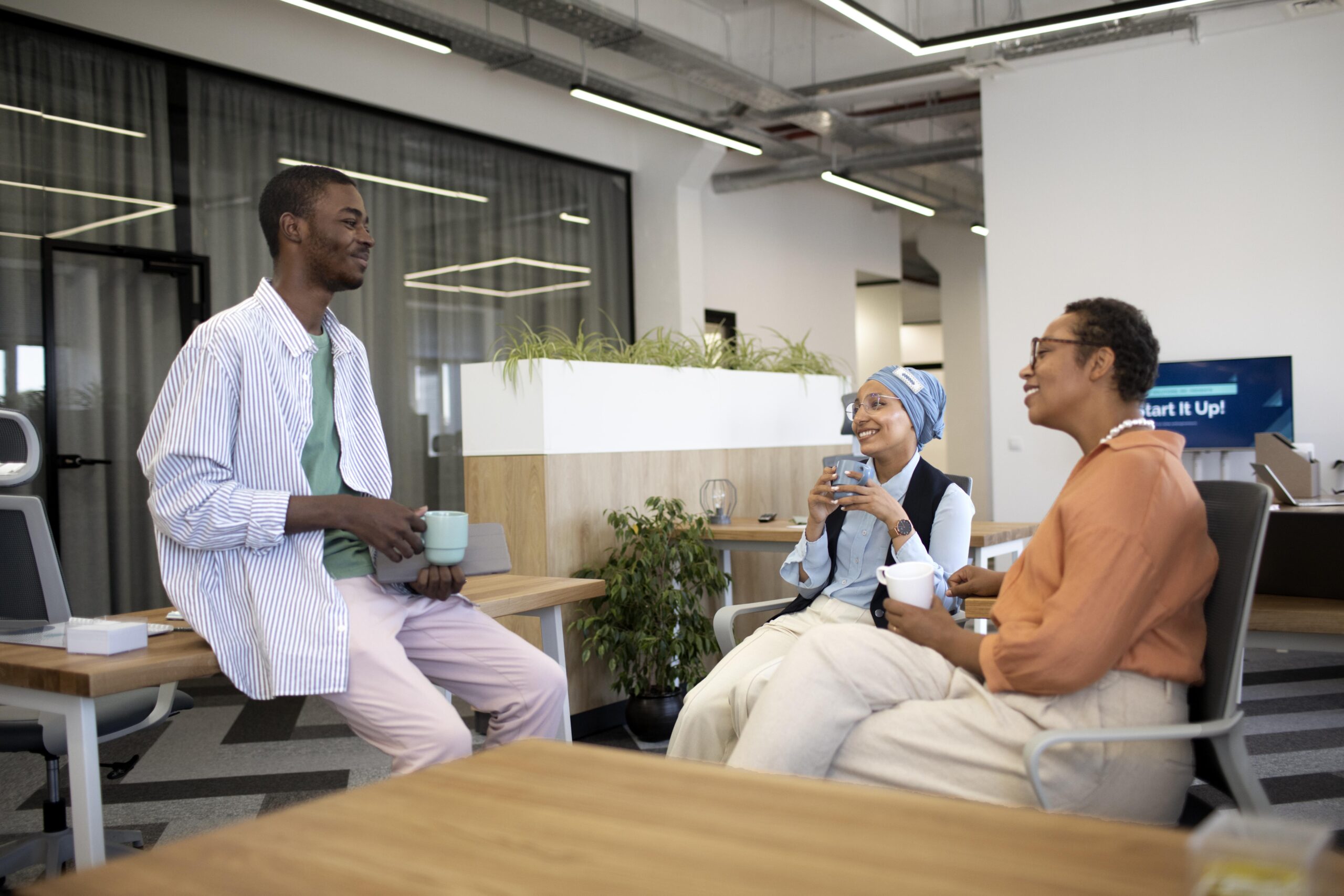 new-male-employee-conversing-with-female-colleagues-his-new-office-job